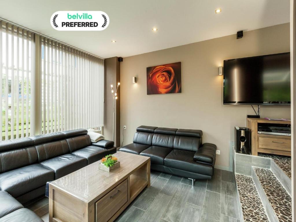 Una sala de estar con un sofá y un televisor de pantalla plana. en Beachside Stay w Sauna, en Middelkerke