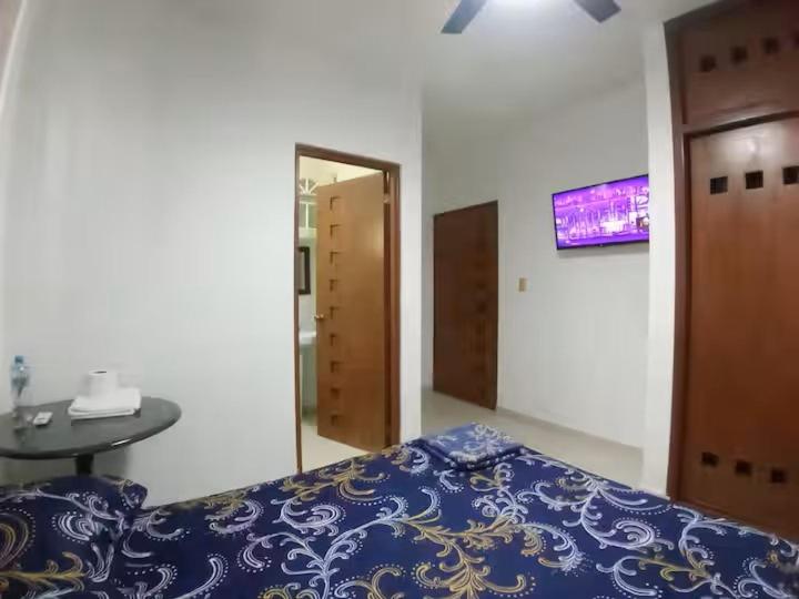 a bedroom with a bed and a table and a mirror at En la 96 in Cancún