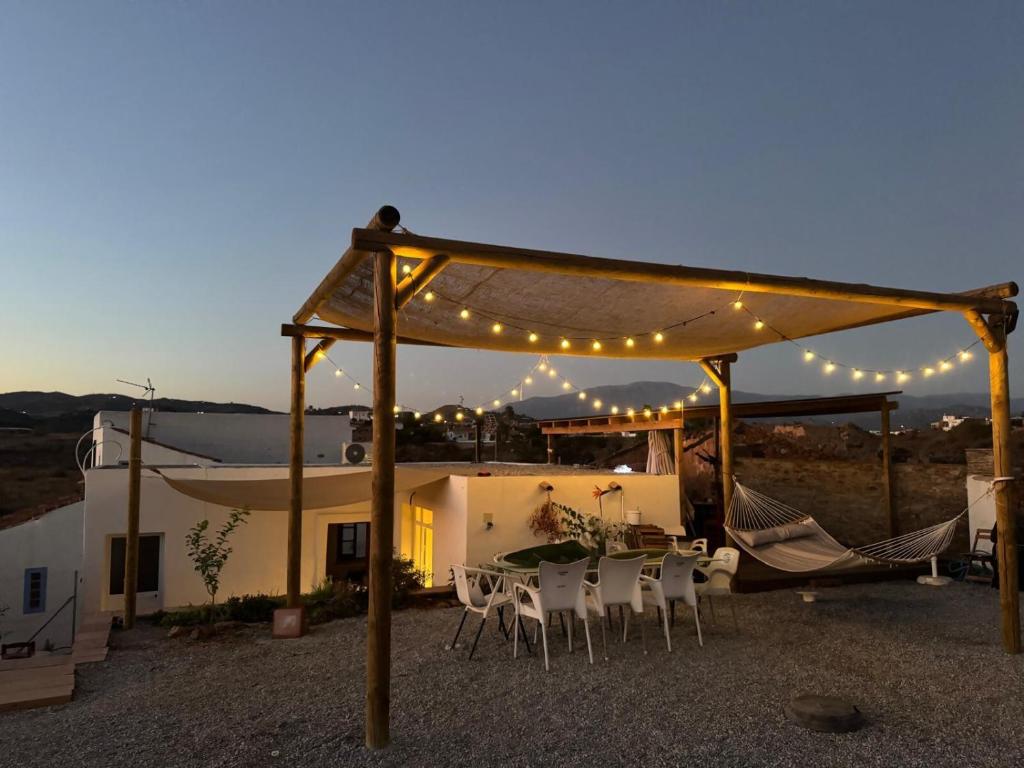Un patio con mesa, sillas y luces. en El Oasis de los Jarales, en Almayate Alto