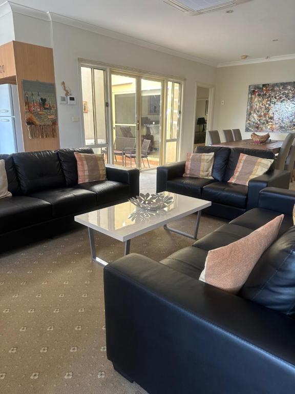 Una sala de estar con sofás y una mesa de café. en Spacious Williamstown Apartment with Free Parking, en Williamstown