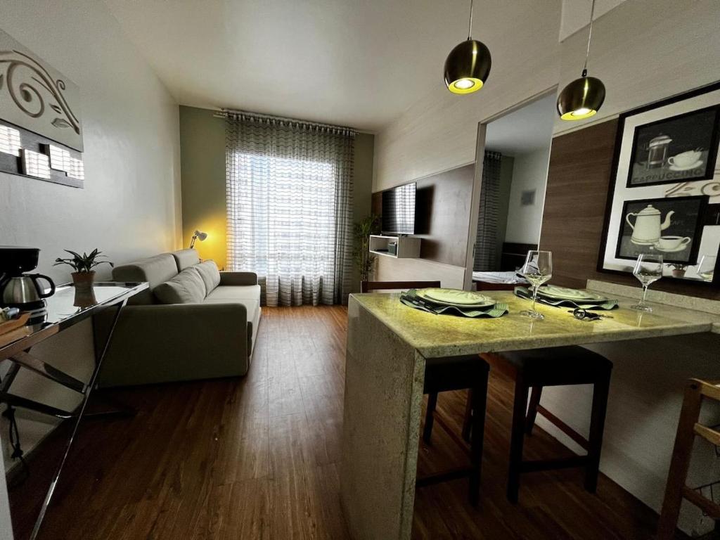 a living room with a couch and a table with chairs at Flat dentro de hotel de Luxo proximo ao shopping in Manaus