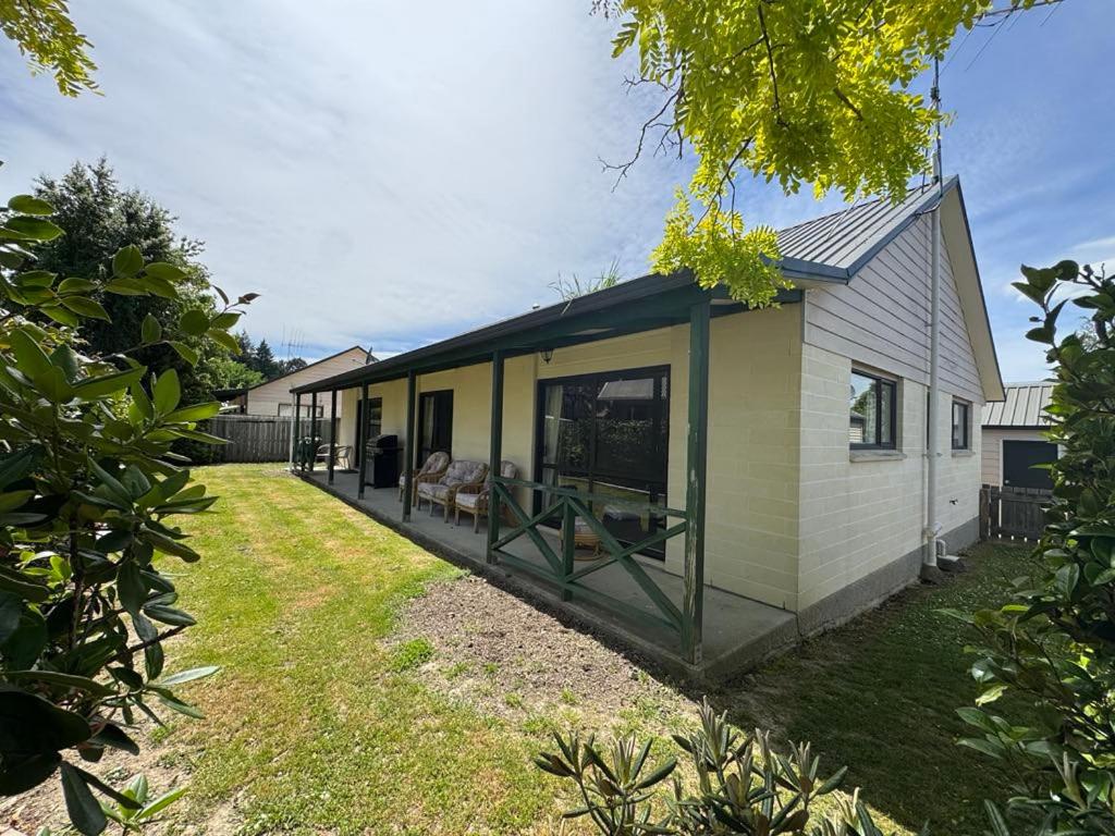 a green and white house with a yard at 8b Rippingale Road in Hanmer Springs