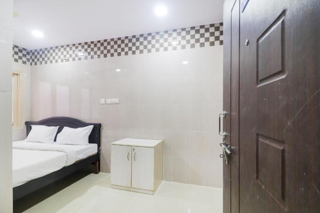 ハイデラバードにあるHotel O Aroma Classic Near Nampally Railway stationの小さなベッドルーム(ベッド1台、ドア付)