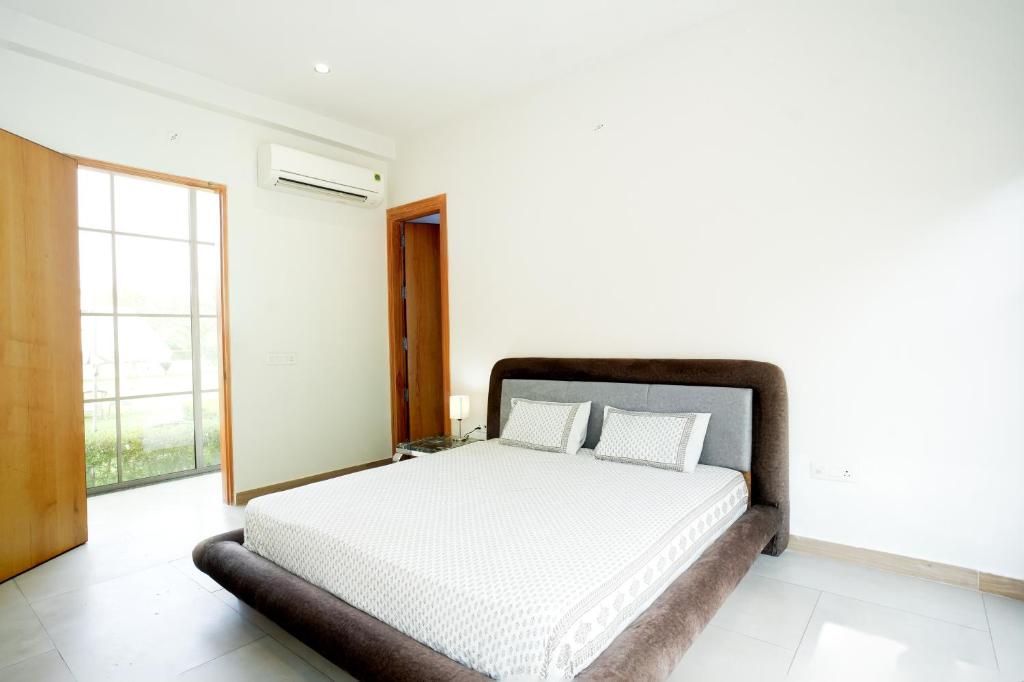 ein Schlafzimmer mit einem weißen Bett und einem großen Fenster in der Unterkunft Hotel Castle in Pānīpat