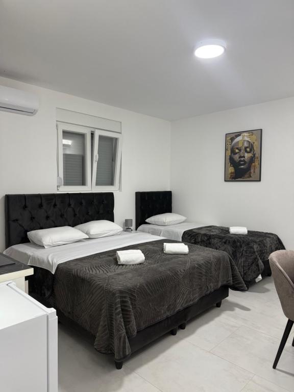 a bedroom with two beds and a chair at Apartmani Zabjelo in Podgorica