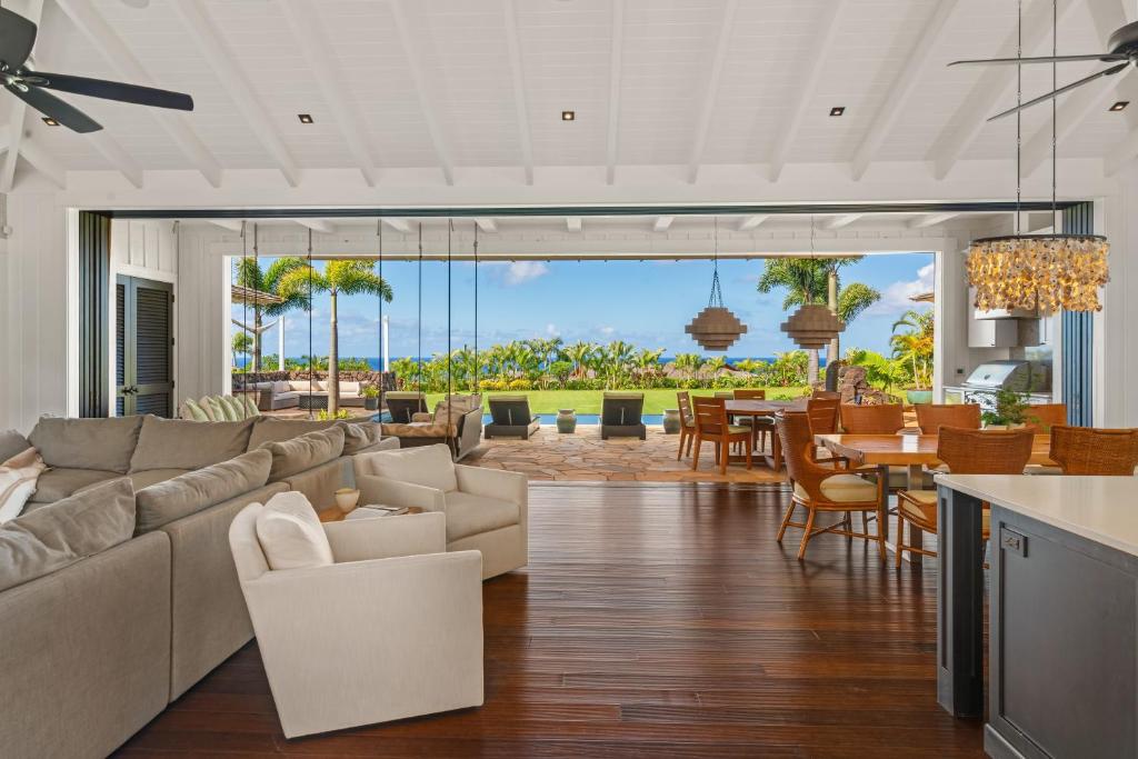 a living room with a couch and a dining room at Luxury 6BR Ocean View Estate Home in Kukuiula in Kukuiula