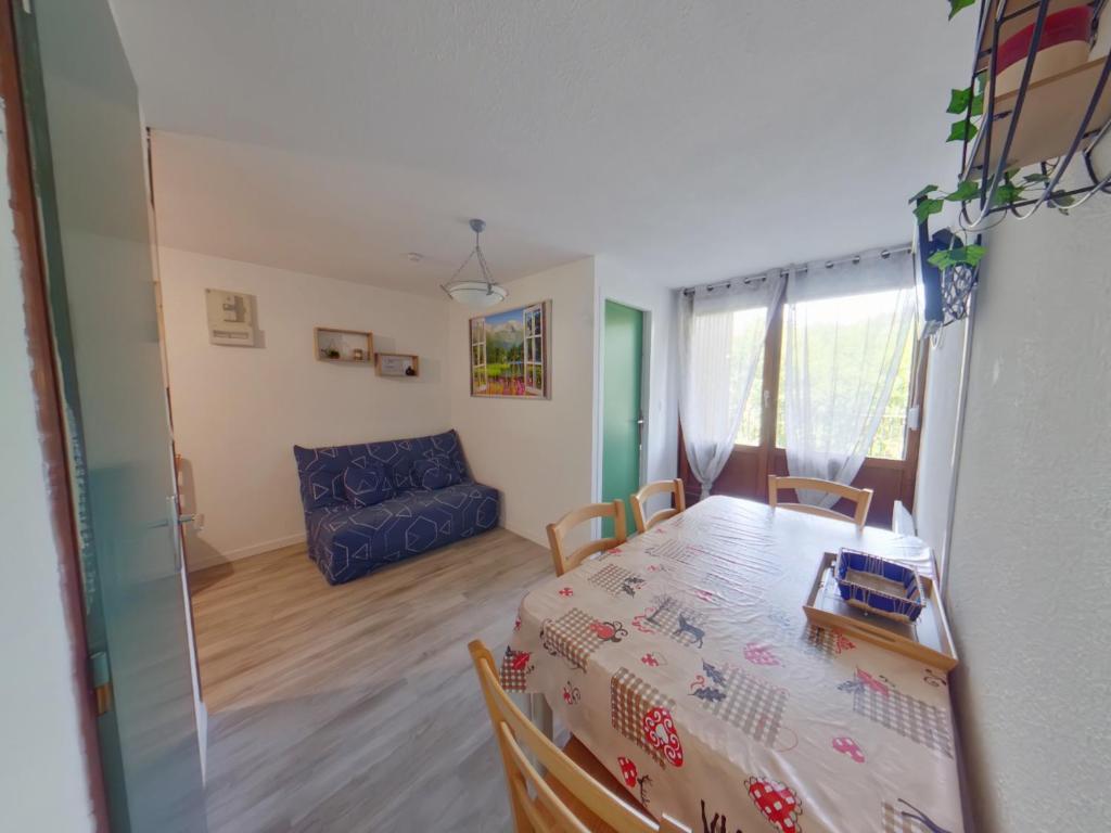 Zimmer mit einem Tisch, Stühlen und einem Sofa in der Unterkunft Appartement avec Terrasse aux Rousses, 500m Centre, 4 Pers. - FR-1-834-10 in Les Rousses
