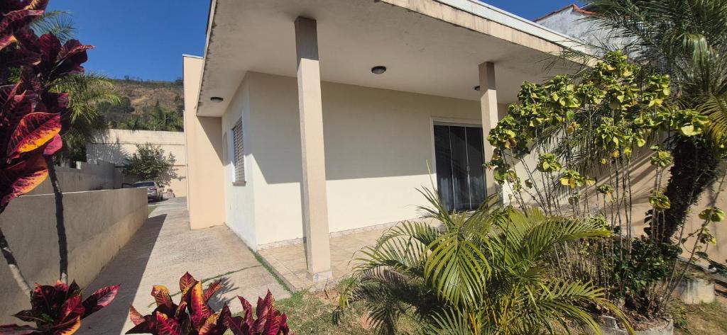 a white house with palm trees in front of it at Casa shalom in Serra Negra