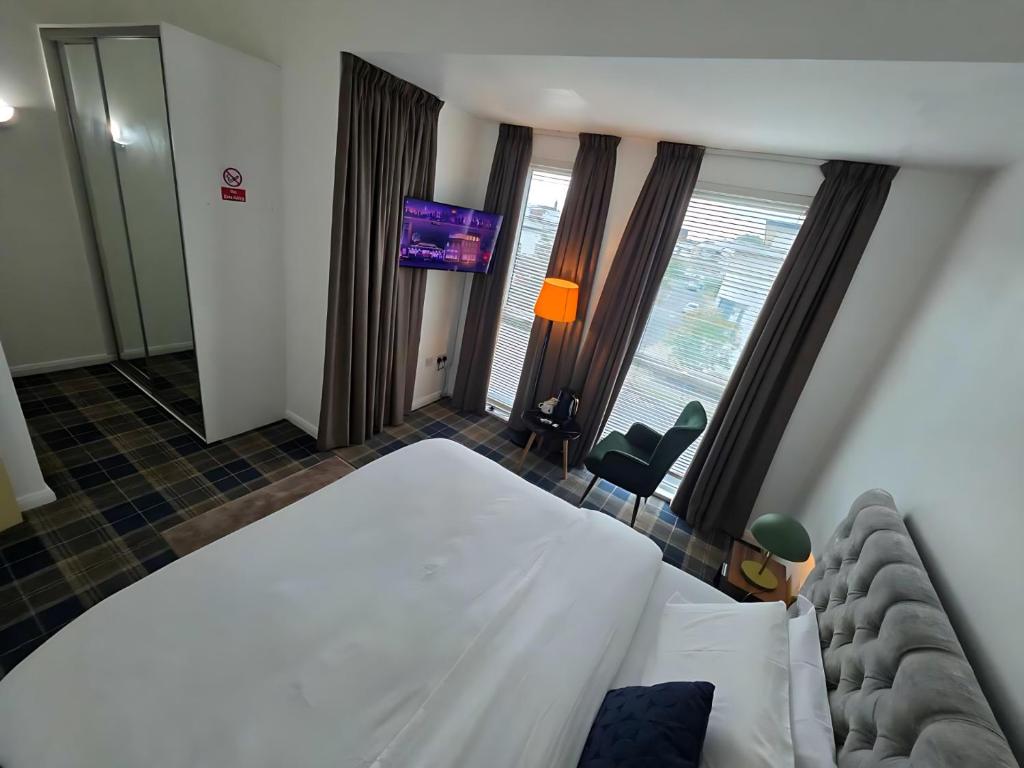 a hotel room with a bed and a television at MetroStay Manchester in Manchester