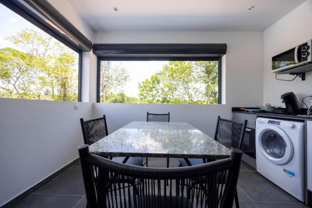 a kitchen and dining room with a table and chairs at Oreo - Destination Guyane in Saint-Laurent du Maroni