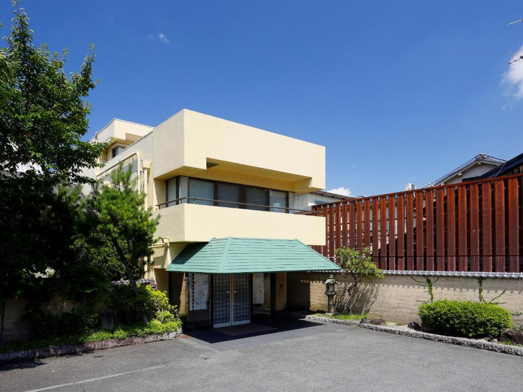 a building with a green awning in front of it at Kanko Hotel Tamaru in Nara