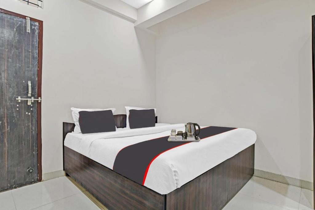 ein Schlafzimmer mit einem großen Bett mit einem hölzernen Kopfteil in der Unterkunft HOTEL DREAM PALACE in Indore