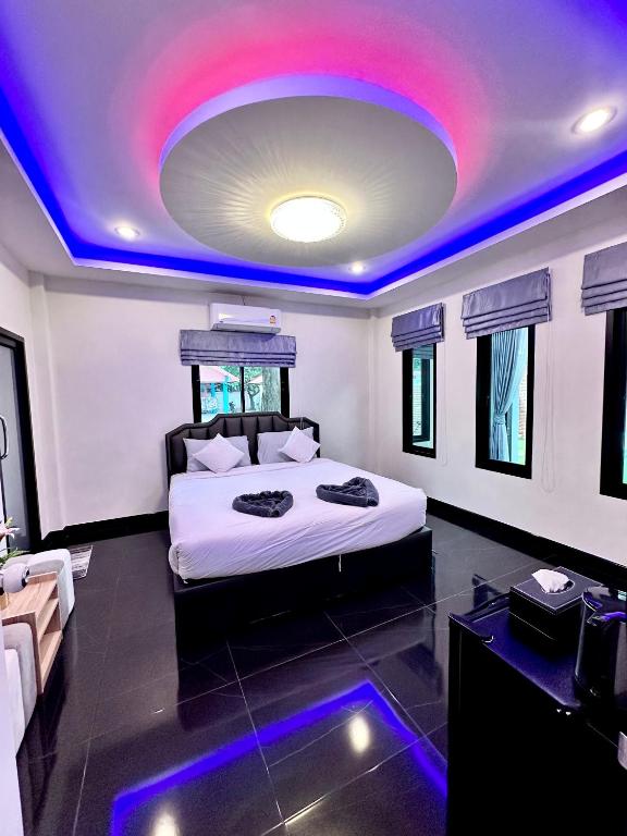 a bedroom with a large bed with a purple ceiling at VS Resortวีเอส รีสอร์ท ท่าศาลา in Ban Thang Khun