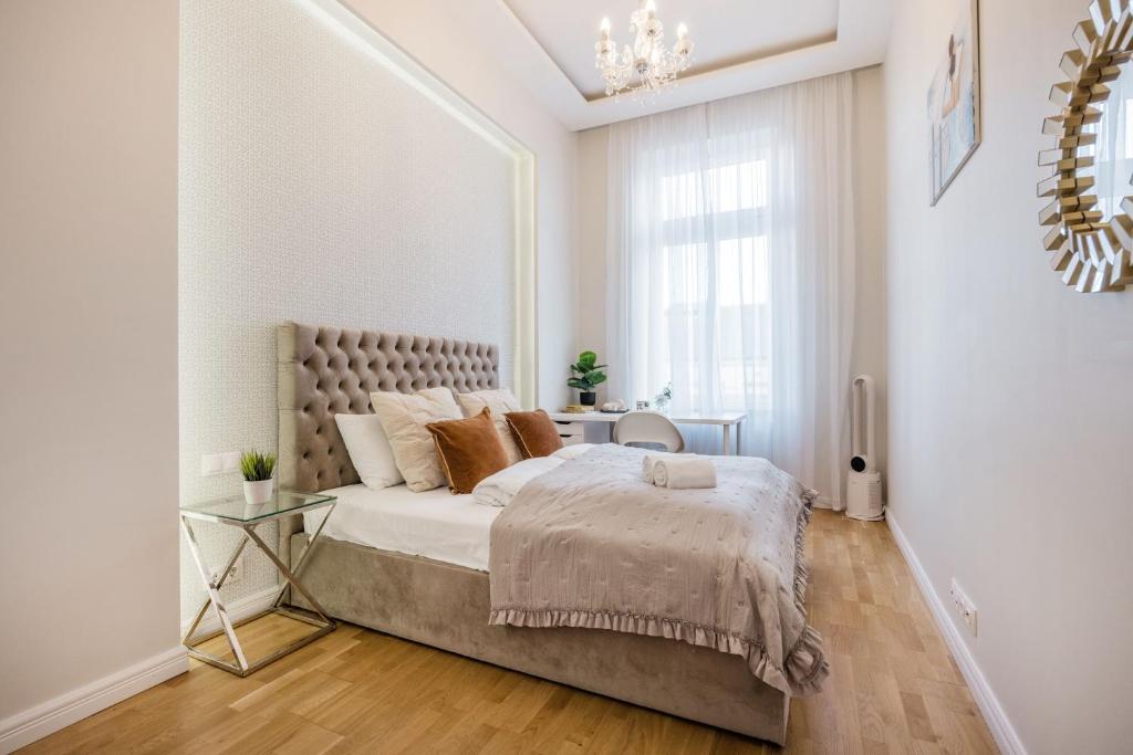 um quarto branco com uma cama grande e um lustre em Synagogue Skyline View Walk to Deák & Fashion St em Budapeste