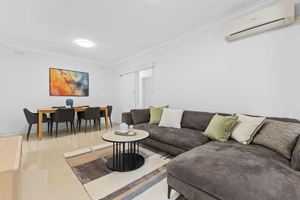 a living room with a couch and a table at Prime location 3-bedder just moments from Central Park in Glen Iris