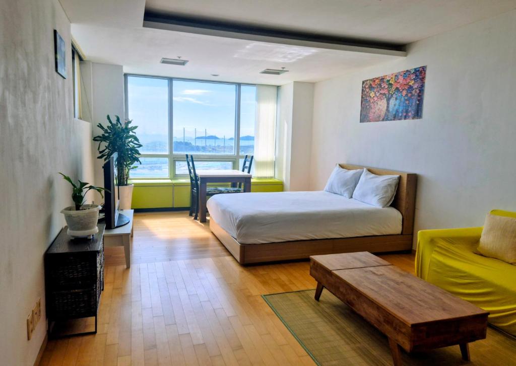 a bedroom with a bed and a table and a couch at Cozy - Experience Home like Comfort Studio in Incheon
