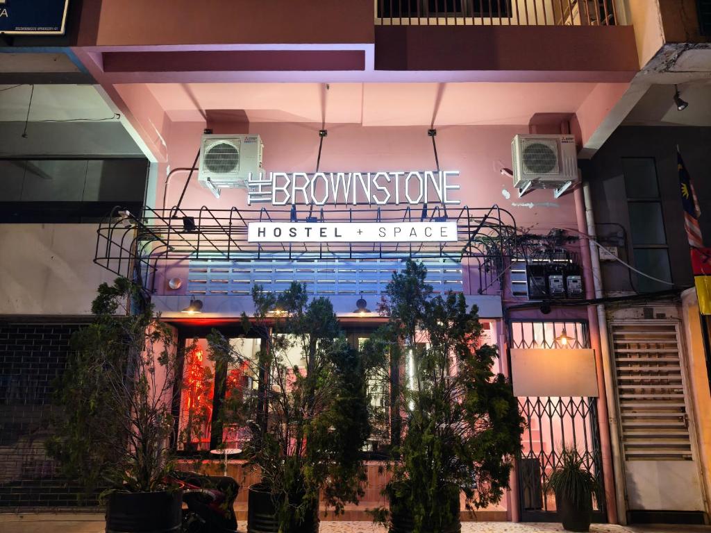 a building with a sign on the front of it at The Brownstone Hostel & Space in Ipoh