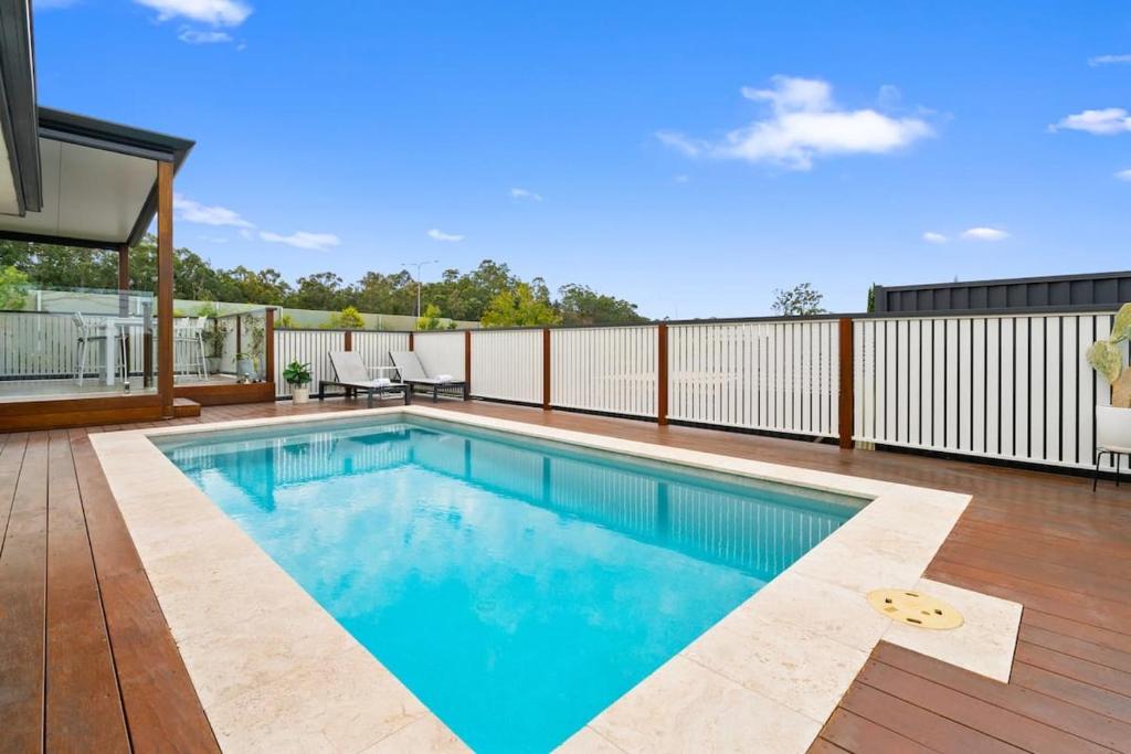 a swimming pool on a patio with a deck at Burleigh Heads Family Getaway in Gold Coast