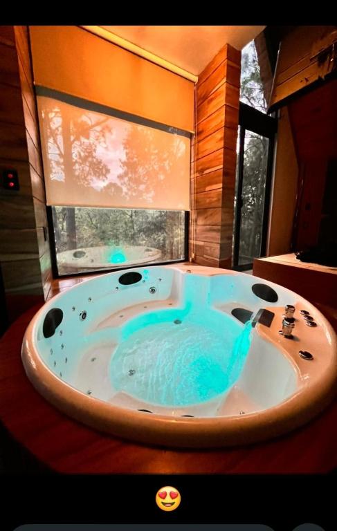 a bathroom with a jacuzzi tub in front of a window at Chalet San Marcos in Mazamitla