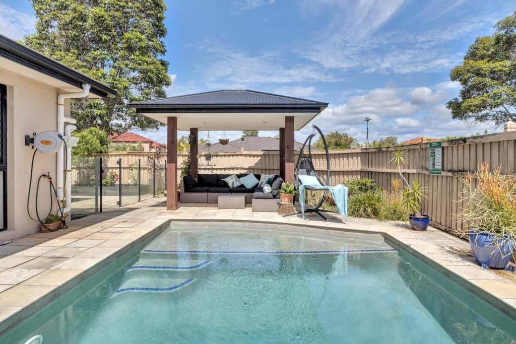a swimming pool in a backyard with a gazebo at Beautiful Family House with Pool and BBQ in Gold Coast