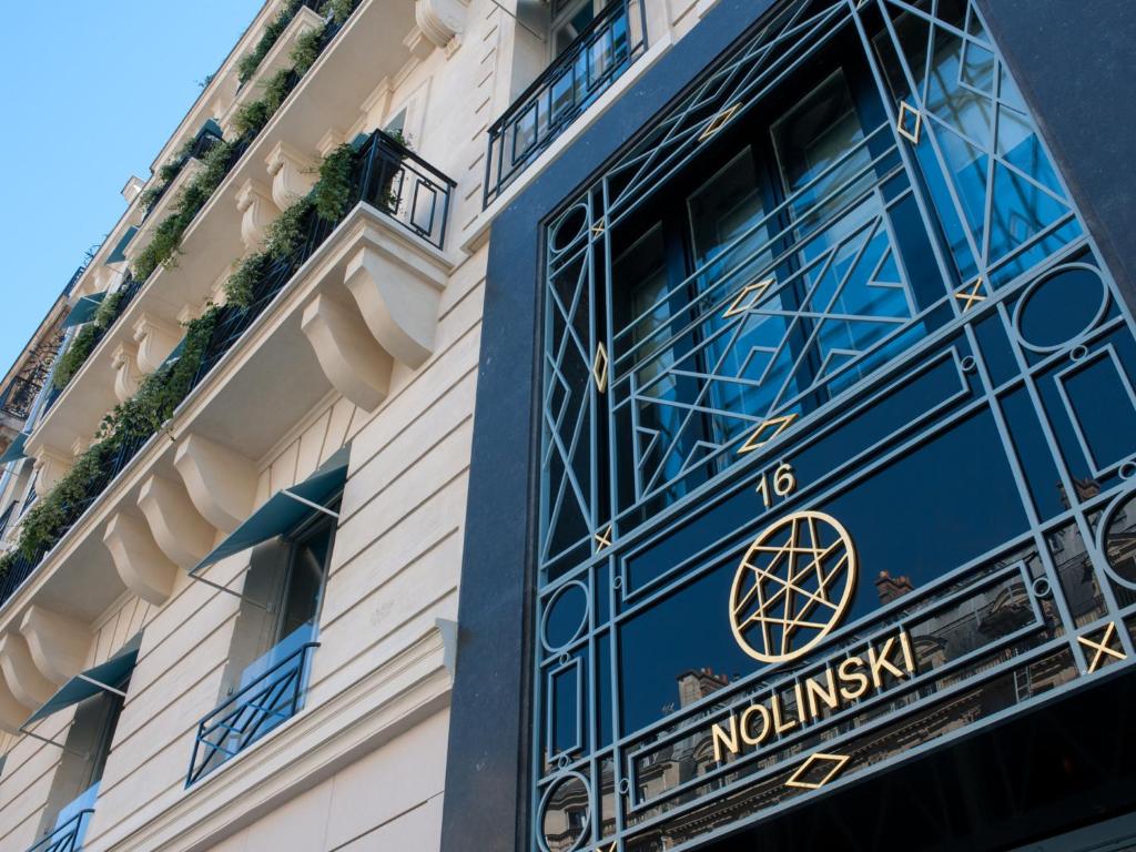 un bâtiment avec une porte bleue portant les mots noiliki dans l'établissement Nolinski Paris - Evok Collection, à Paris