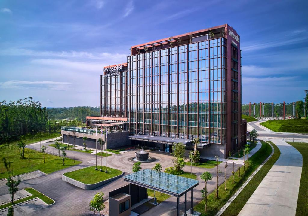 a tall red building with a lot of windows at Swissôtel Nusantara in Penajam