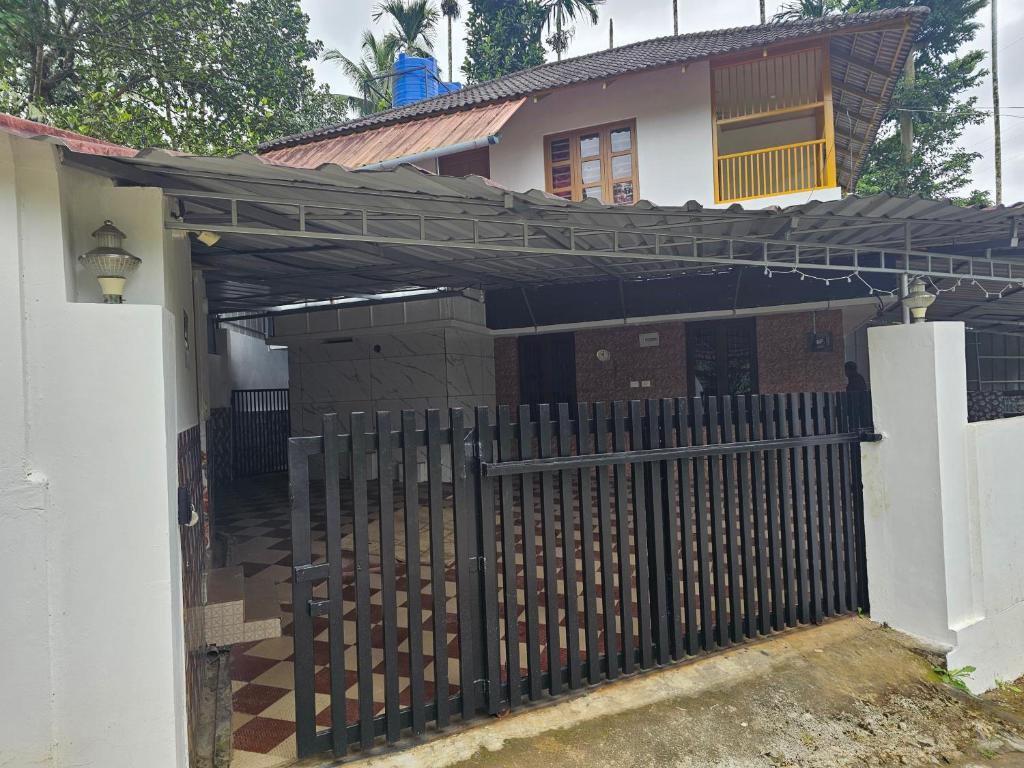 a house with a black fence and a gate at Hamai nisha villa in Ambalavayal