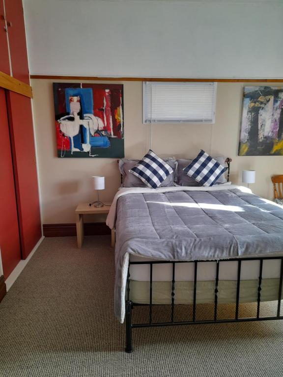 a bedroom with a bed with blue and white pillows at Great place to stay in Gisborne