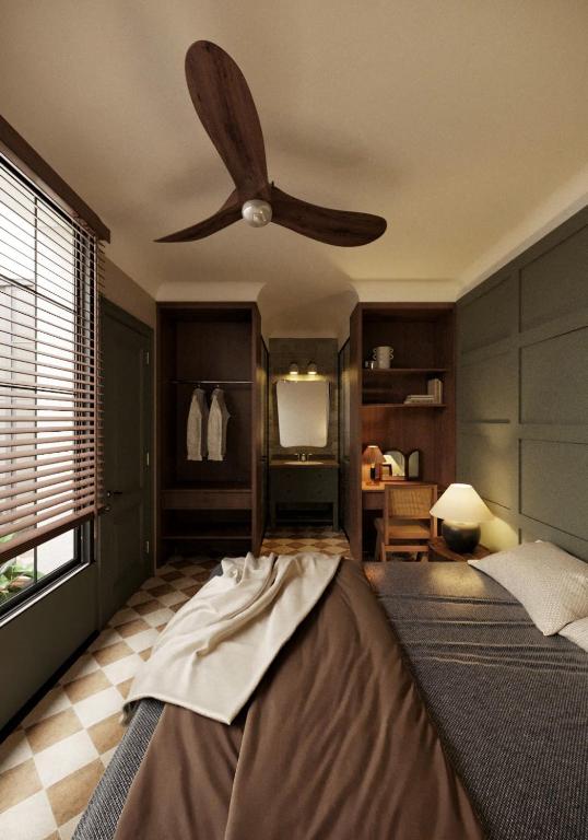 a bedroom with a ceiling fan and a bed at A Stay In Bàu Vá in Hue