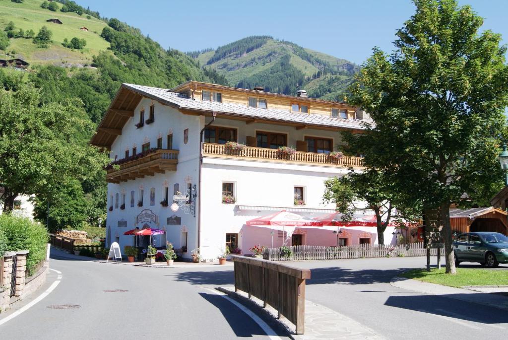 ein großes weißes Gebäude an der Seite einer Straße in der Unterkunft Gasthof Andrelwirt Rauris in Rauris