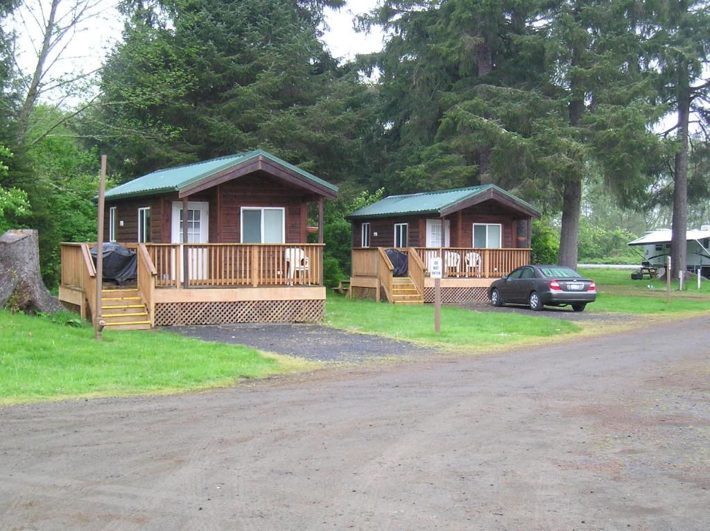 eine kleine Hütte mit einem davor geparkt in der Unterkunft Seaside Camping Resort Studio Cabin 3 in Seaside