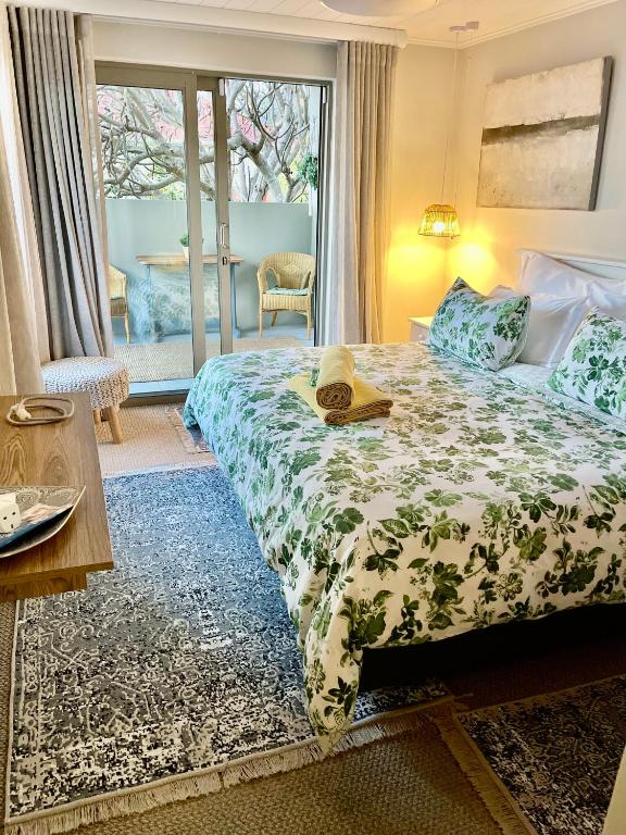 a bedroom with a bed with a hat on it at OceanBreeze50 Stylish Garden Route Stay in Central Mossel Bay in Mossel Bay