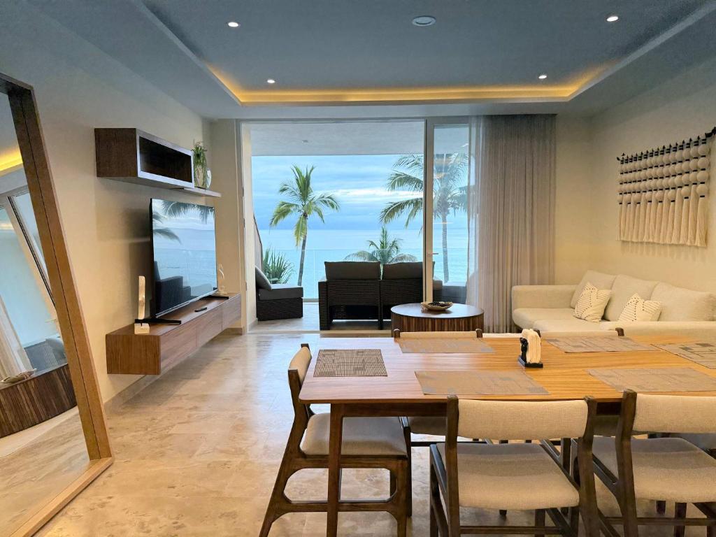 a living room with a table and a living room with the ocean at Luxury by the sea unmatched comfort in Bucerías