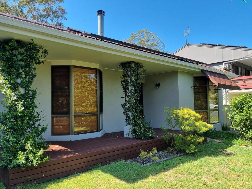 une maison avec un porche en bois avec du lierre dans l'établissement Monterra Ave Magic, à Hawks Nest