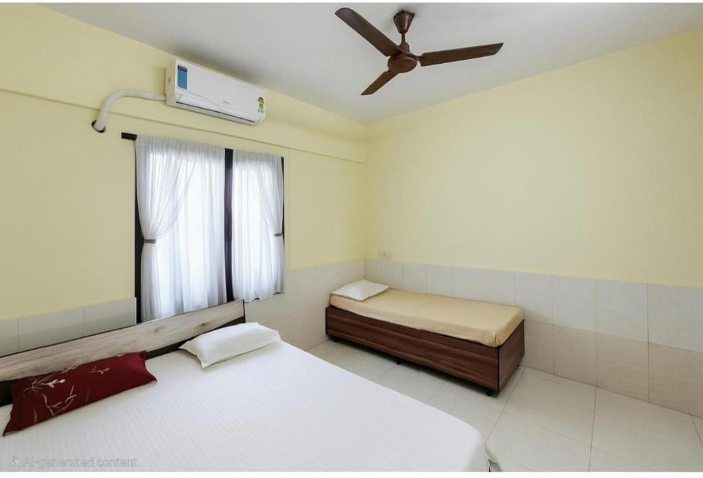 a bedroom with two beds and a ceiling fan at Ac Private Room At ovale naka Ghodbunder road Thane West in Thane