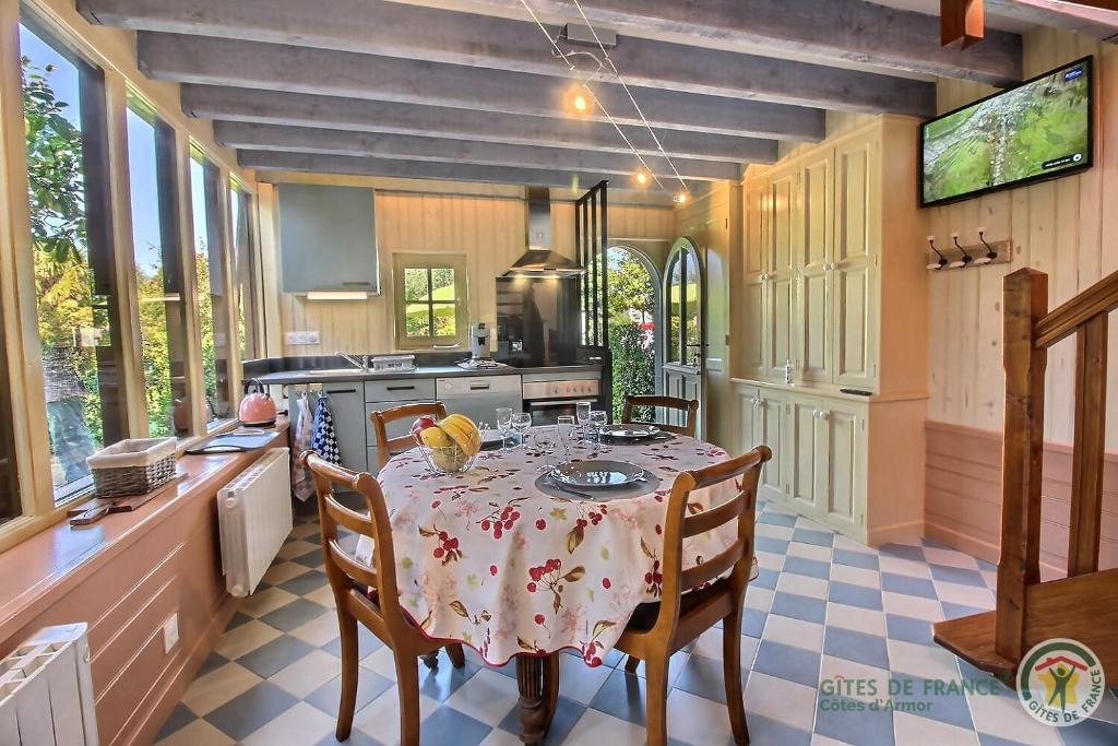a kitchen with a table with chairs and a stove at Ker desiree in Plélo
