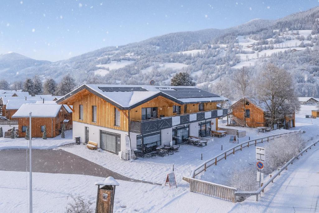 a large wooden house with snow on the ground at Apartments Kreischberg Chalets by ALPS RESORTS in Sankt Lorenzen ob Murau
