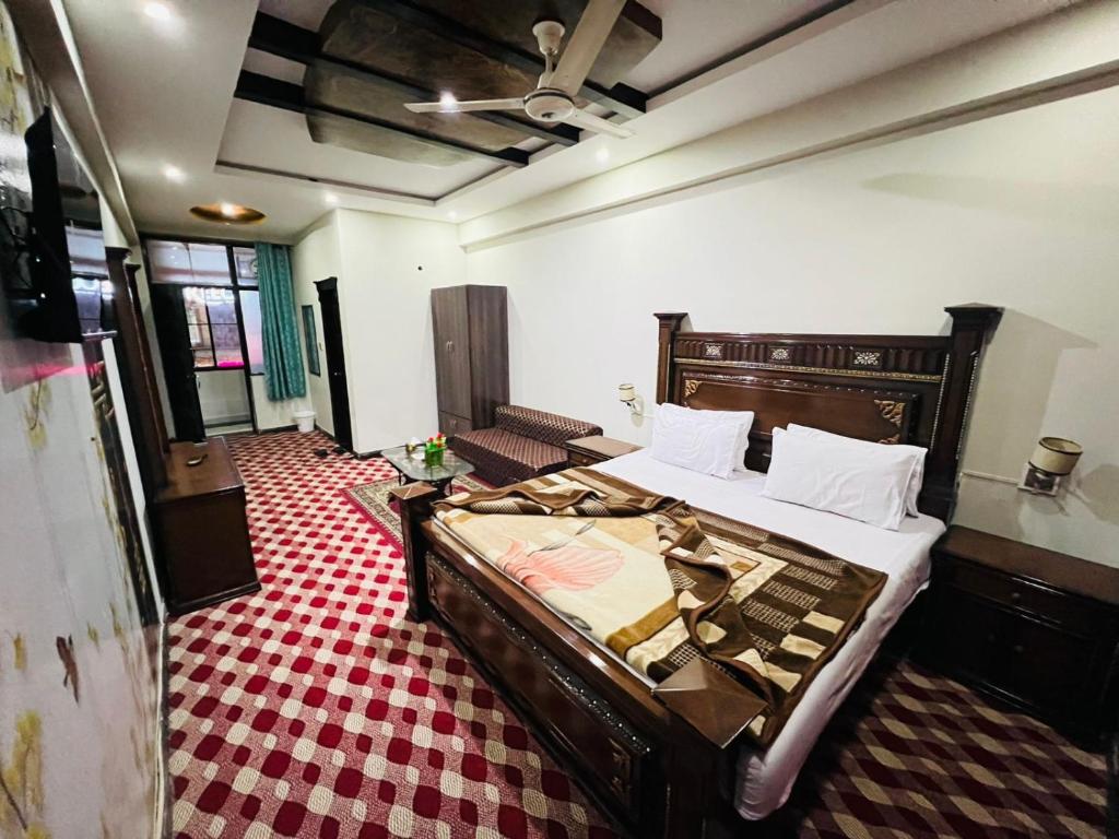 een slaapkamer met een groot bed in een kamer bij UK Hotel in Abbottābād