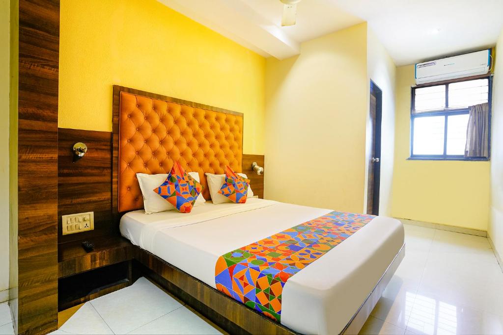 a bedroom with a large bed with yellow walls at Via New Silver Elite in Mumbai