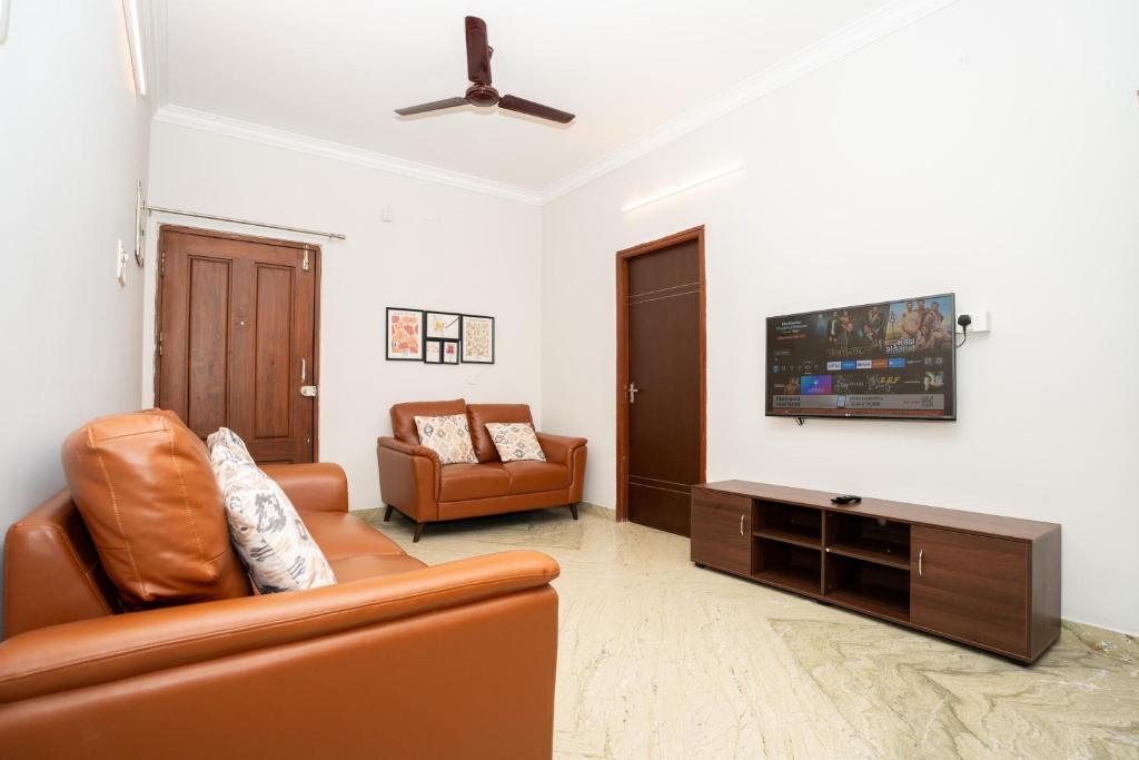 a living room with a couch and a flat screen tv at Cozy 2BR in Chennai