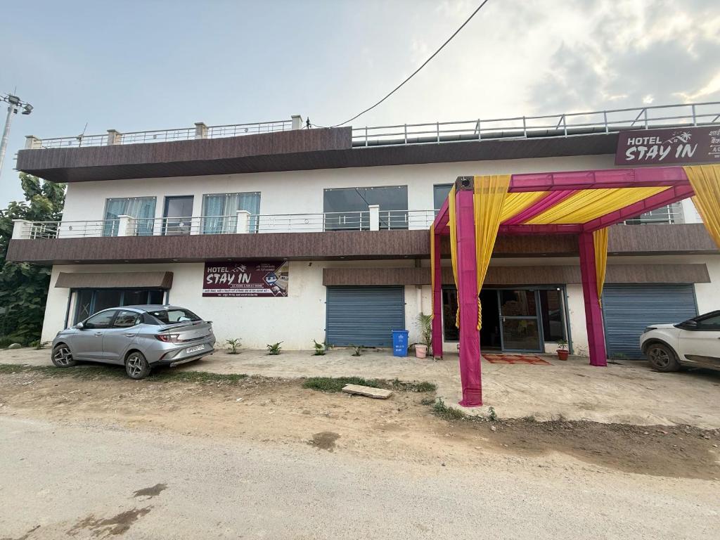a building with cars parked in front of it at Hotel O stay inn in Shivāpur