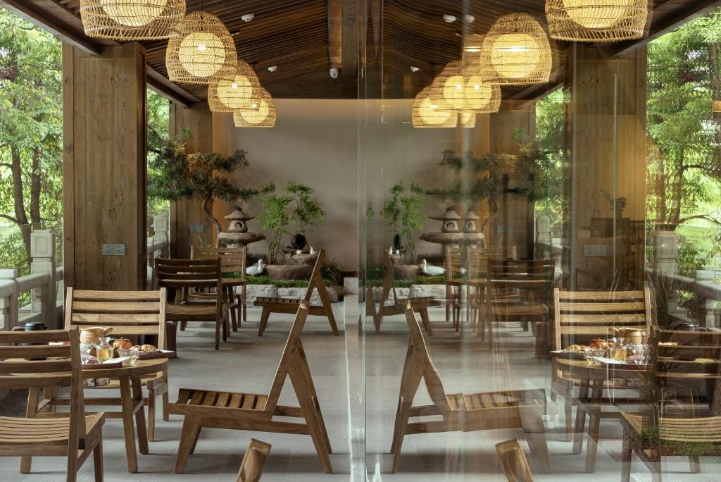 a restaurant with tables and chairs and chandeliers at Shishe Spring Designer Homestay in Dujiangyan