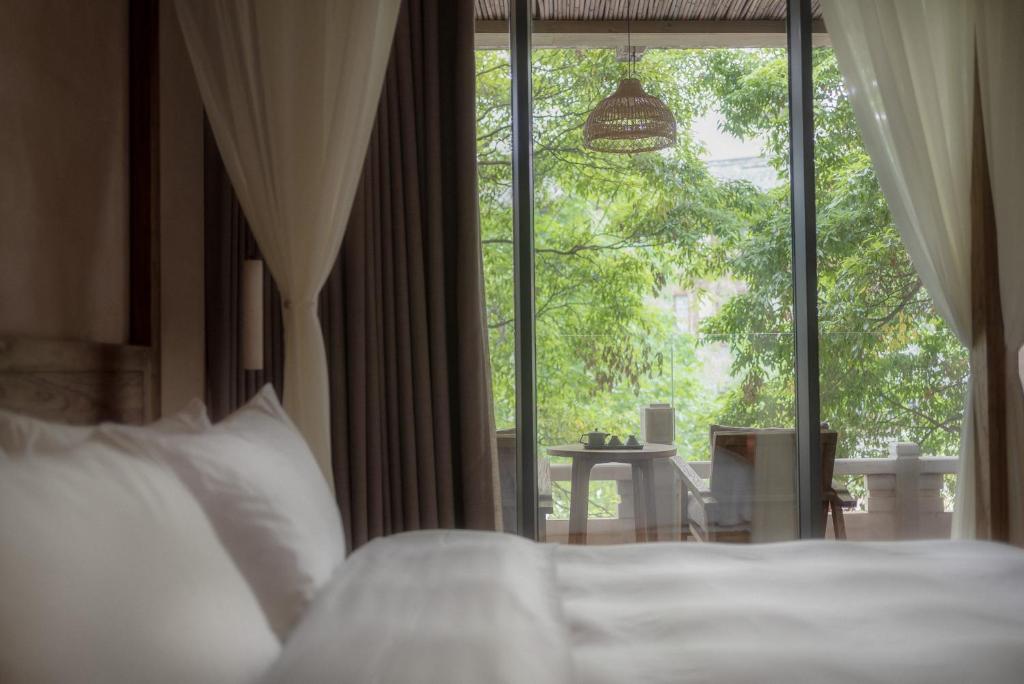 a bedroom with a bed and a large window at Shishe Spring Designer Homestay in Dujiangyan