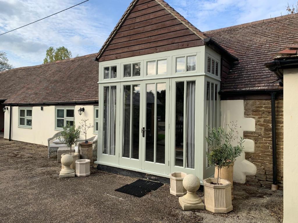 an extension to a house with a conservatory at The Byre, at Cradle Barn offering a king suite in Abingdon