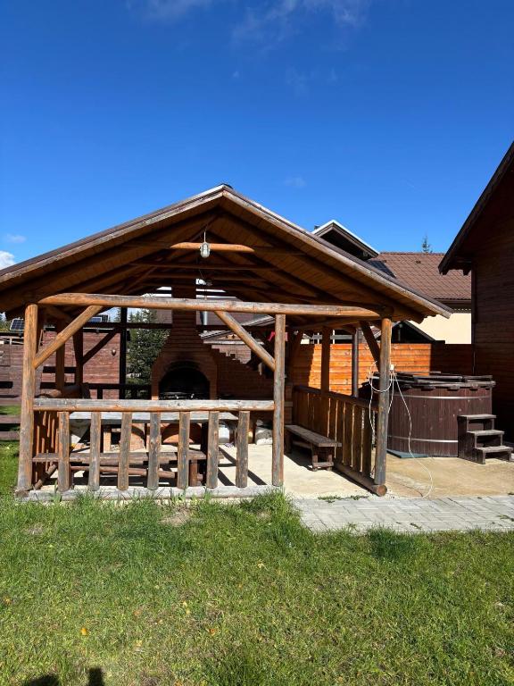 un pabellón de madera frente a un edificio en Szakács Vendégház, en Borzont