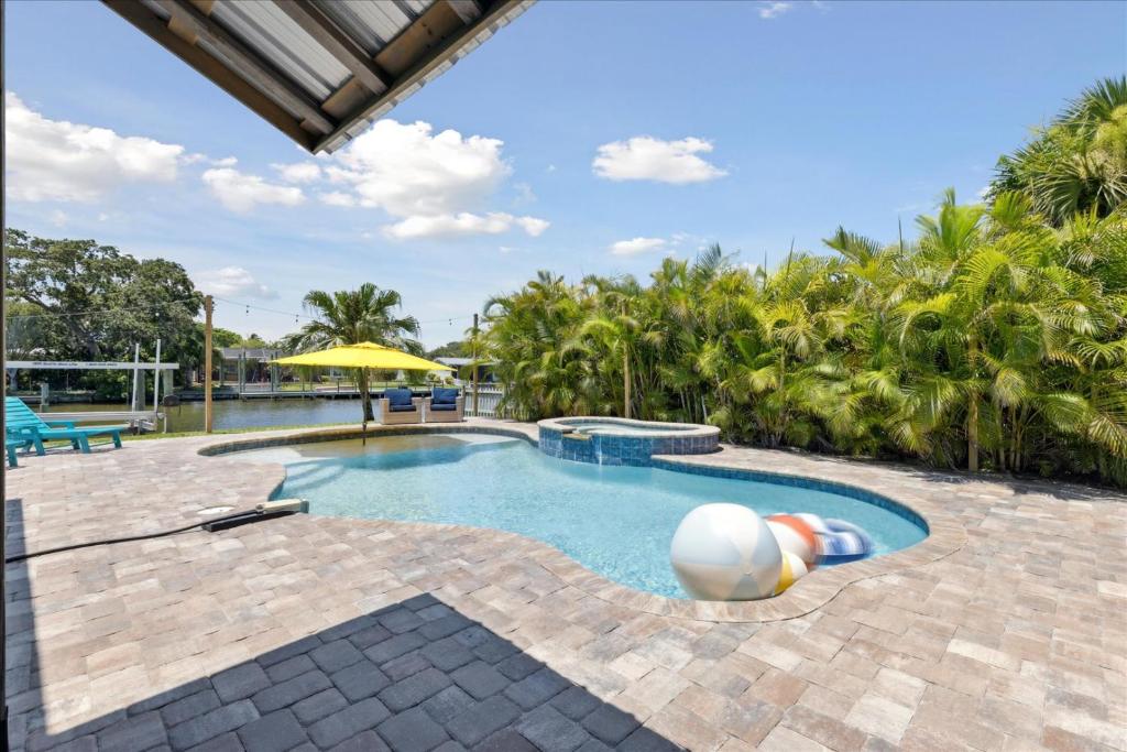 a swimming pool with a beach ball and an umbrella at 436 Cocoa Isles Blvd in Cocoa Beach
