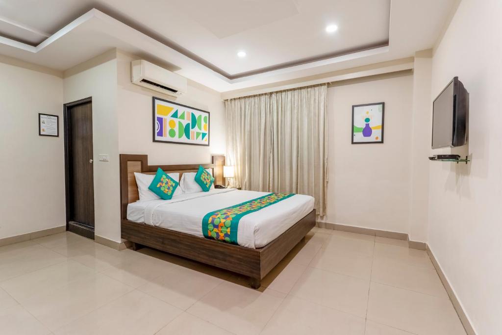 Un dormitorio con una cama y un televisor. en Treebo Millenium Suites, en Bangalore