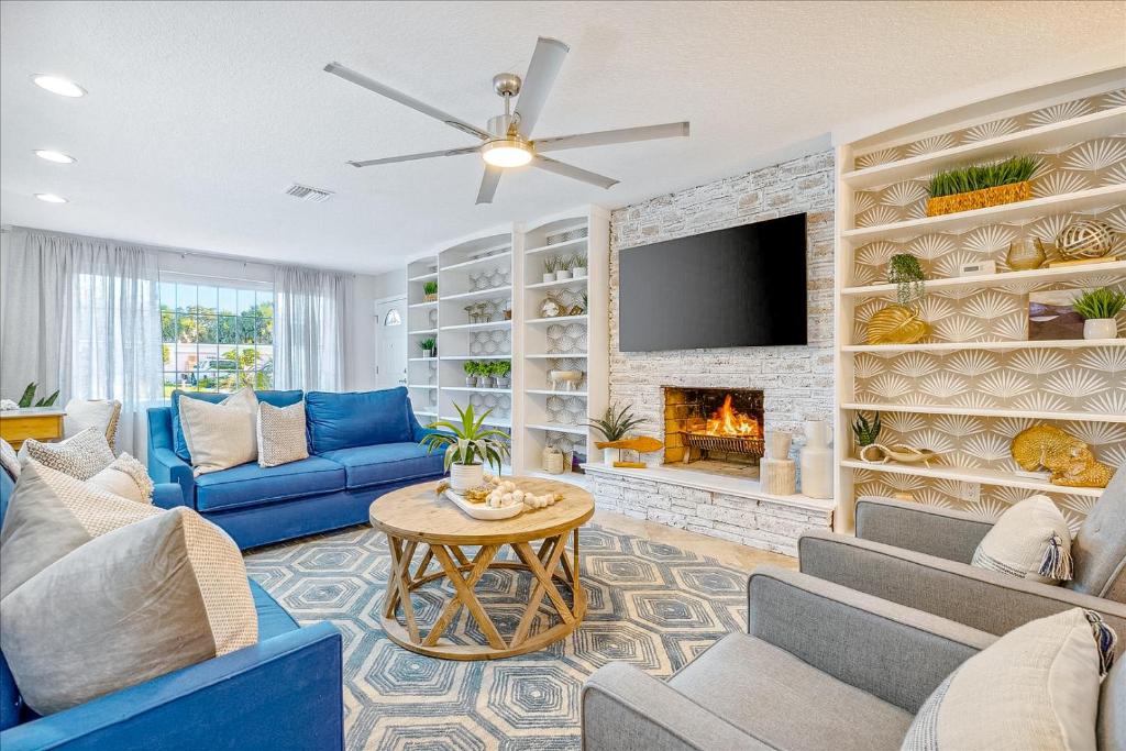 sala de estar con sofás azules y chimenea en 120 E Park Ln, en Cocoa Beach