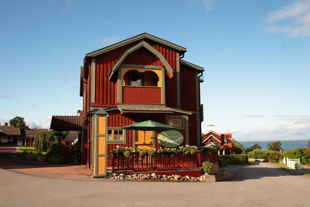 a red house with a fence in front of it at Lustigsgården Boutique Hotel in Rättvik