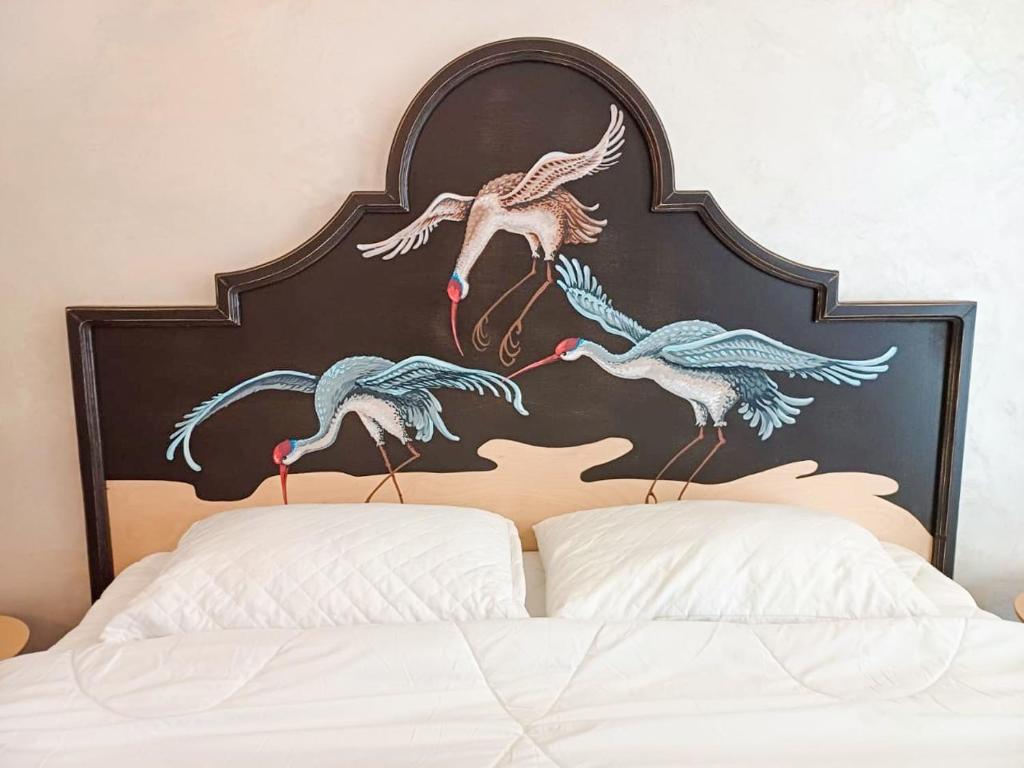 a painting of birds on the headboard of a bed at Kyiv Panna Apartment in Kyiv
